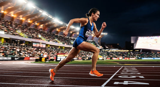 Female endurance athlete running on a track at high speed with dramatic cinematic stadium lighting and sharp fine details.