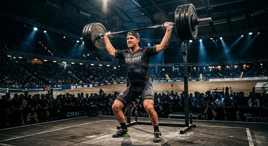 Professional high-speed athletic action photography of a cyclist lifting a heavy barbell with moody cinematic stadium lighting