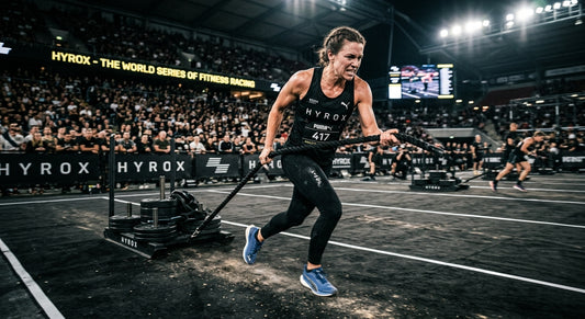 A determined HYROX athlete performing a powerful sled pull in a dramatic, cinematic stadium setting with high-speed motion blur.