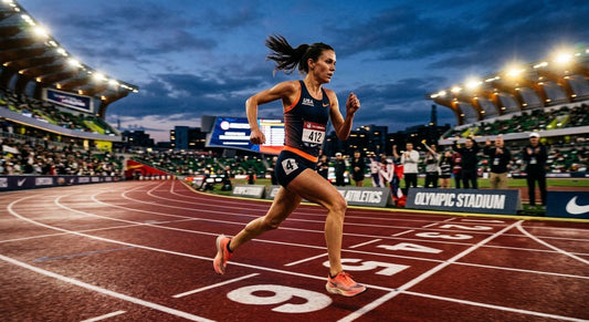 A professional endurance runner sprinting on a track at dusk with dramatic stadium lighting and motion blur.