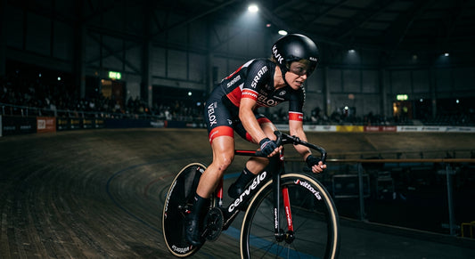 A professional female cyclist in moody, cinematic stadium lighting, reflecting intense focus and athletic precision.