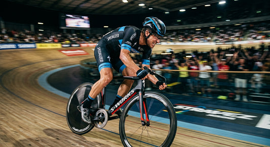 A professional cyclist in a high-speed sprint, captured with motion blur and sharp cinematic stadium lighting.