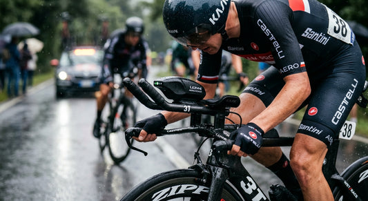 A close-up of a high-tech aerodynamic sensor mounted between carbon fibre aero bars on a time trial bike during a rainy race.