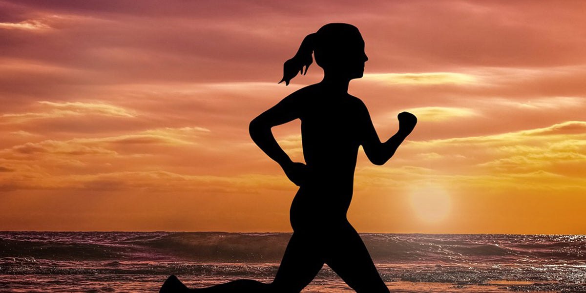 Woman running beach sunset fitness races
