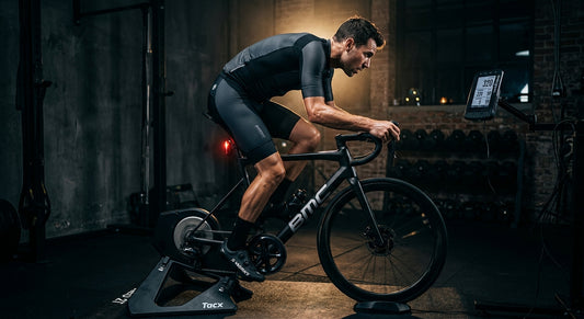 A cyclist training indoors with high-tech gear in a dark, moody gym setting with cinematic lighting.