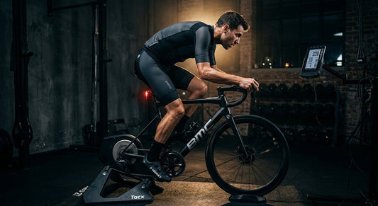 A cyclist training indoors with high-tech gear in a dark, moody gym setting with cinematic lighting.