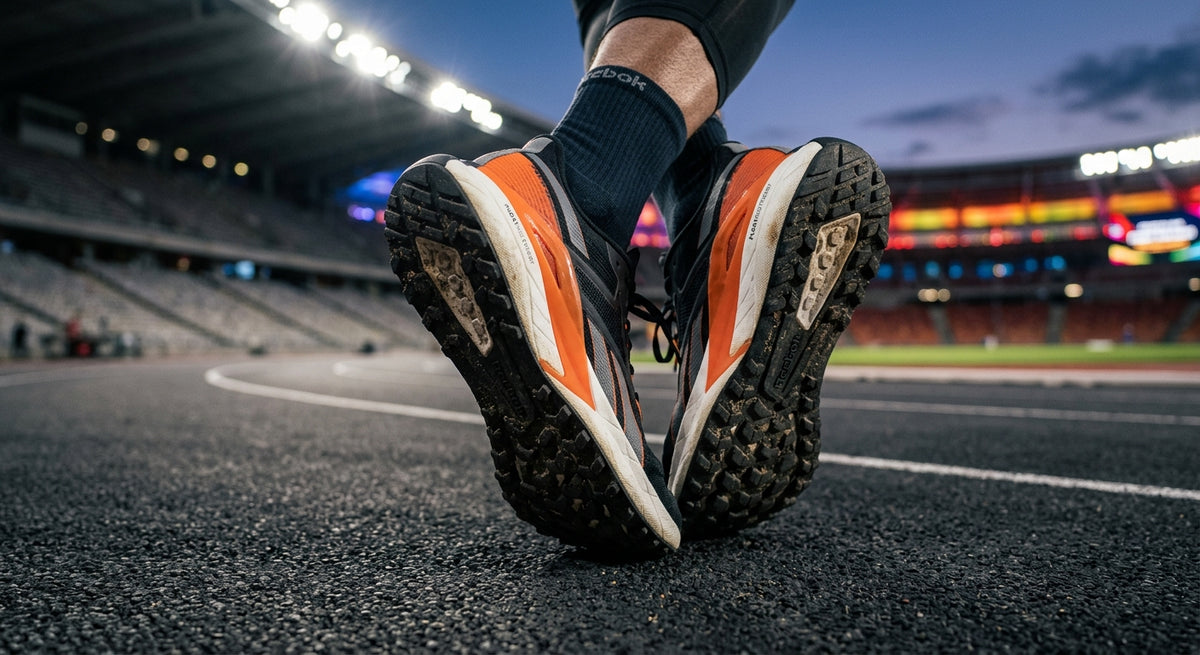 A close-up of the Reebok FloatZig Tread outsole showing aggressive lug geometry and durable rubber textures in a cinematic stadium setting.