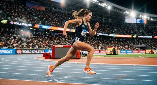 Professional high-speed action shot of a runner wearing prototype Brooks Hyperion Elite 6 shoes on a track, captured in cinematic stadium lighting with motion blur.