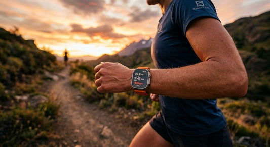 A close-up shot of an Apple Watch Ultra 3 on a runner's wrist during a sunset trail run with dramatic lighting.