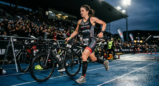 Professional high-speed athletic action photography of a triathlete moving from a bike to a run, moody dramatic contrast, sharp fine details, realistic textures, running motion blur, cinematic stadium lighting