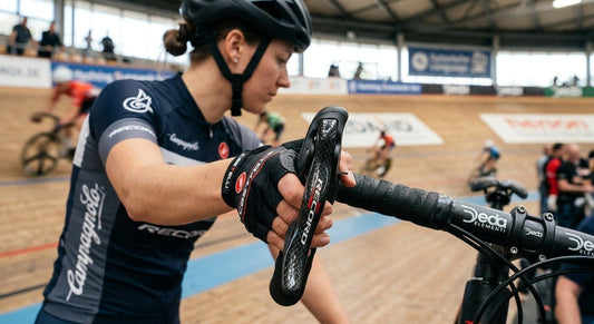 Professional close-up of a Campagnolo Record 13 carbon fibre brake lever against a blurred professional cycling track background.