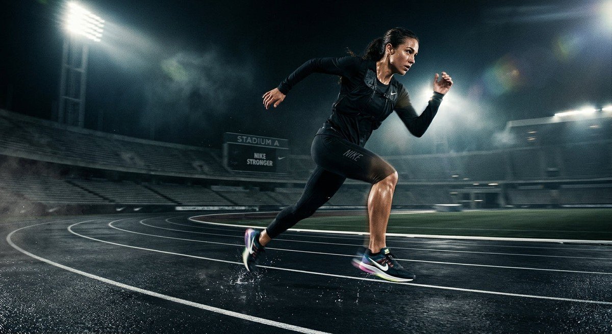 A high-speed action shot of the Nike Structure Plus in a dark, moody stadium environment with dramatic lighting and motion blur.