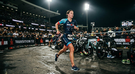 A professional triathlete in a sleek suit sprinting into a transition zone with motion blur and moody stadium lighting.