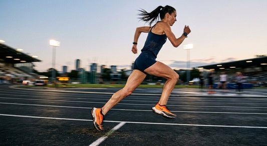 A professional runner captured in high-speed motion with a dramatic motion blur effect and sharp focus on their foot strike during a track workout.