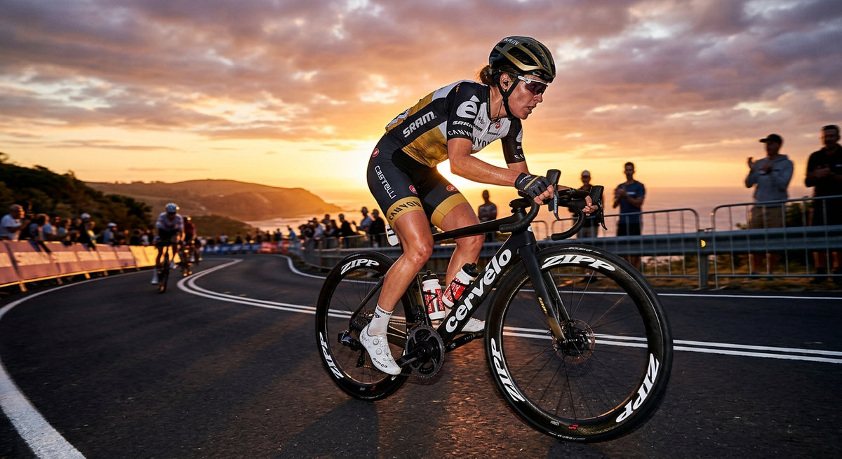A professional road cyclist sprinting on a carbon fibre bike with 60mm deep-section wheels during a sunset race.