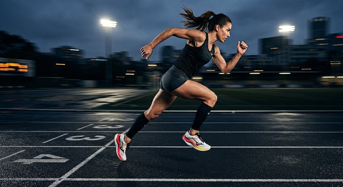 A side-profile shot of the Mizuno Wave Rebellion Pro 4 in a high-speed motion blur capture on a dark running track.