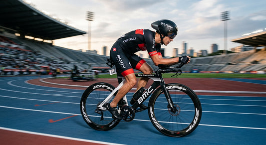 High-speed action shot of a triathlete wearing the Rudy Project Wingdream, showcasing the aerodynamic silhouette against a blurred stadium background.