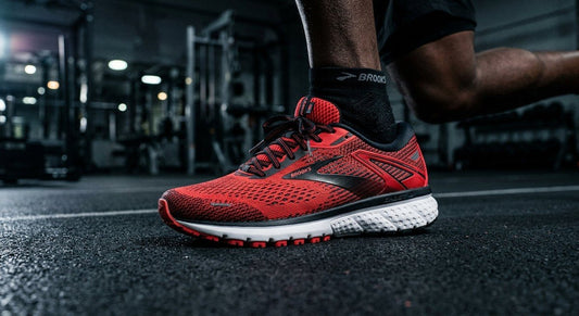 A close-up shot of the Brooks Ghost 18 running shoe showing the detailed engineered mesh texture and vibrant colourway against a dark, moody background.