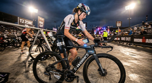 A professional triathlete in a high-speed transition zone, using a smartphone to scan a UWB-enabled tracking tag on a carbon fibre bike frame under dramatic cinematic stadium lighting.