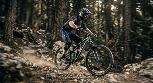 A professional mountain biker riding a high-tech 32-inch wheel bike through a rocky forest trail with dramatic cinematic lighting and motion blur