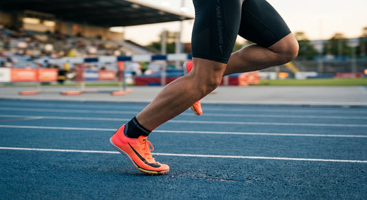 Professional side-profile shot of a high-performance track spike on a synthetic rubber track with motion blur