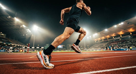 A professional action shot of the Hoka Clifton Pro on a synthetic track with cinematic stadium lighting and motion blur.
