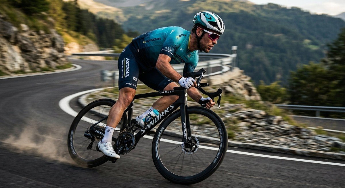 Professional cyclist wearing the Oakley RSLV Lite sunglasses during a high-speed mountain descent with blurred background.