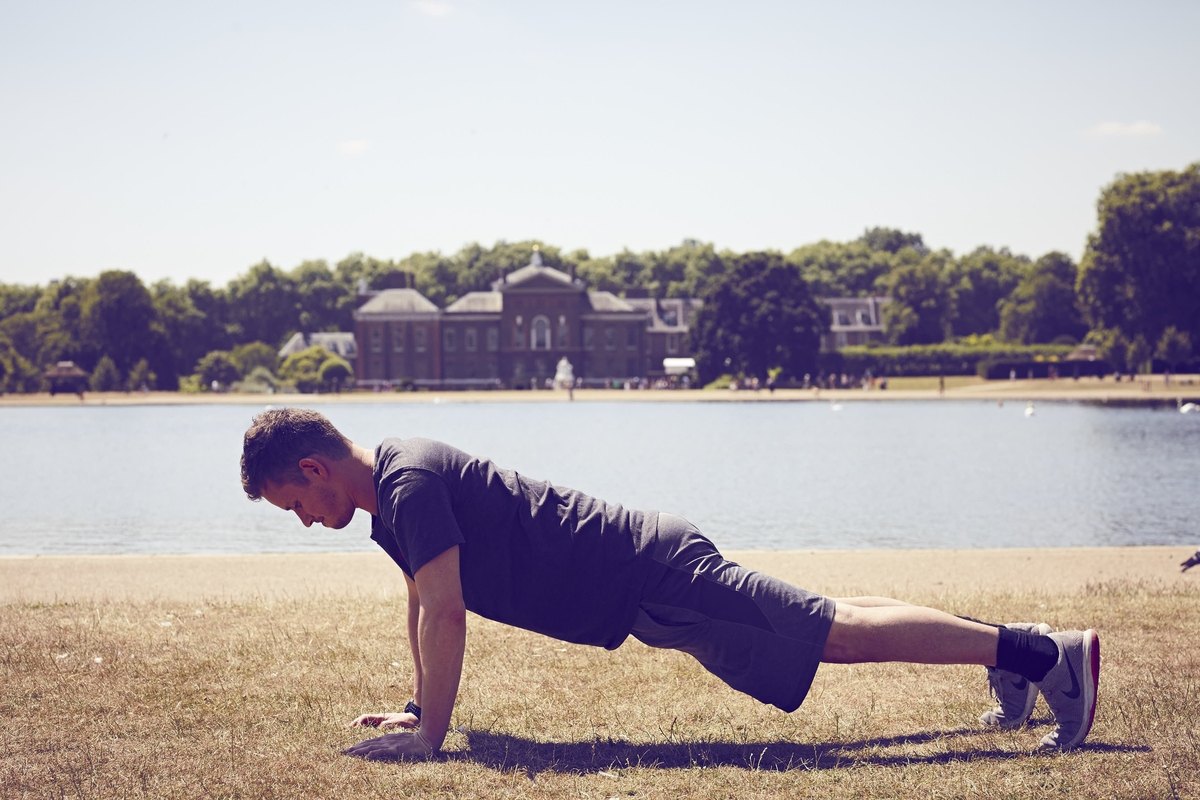 Man Planking By A River Outdoors Strong