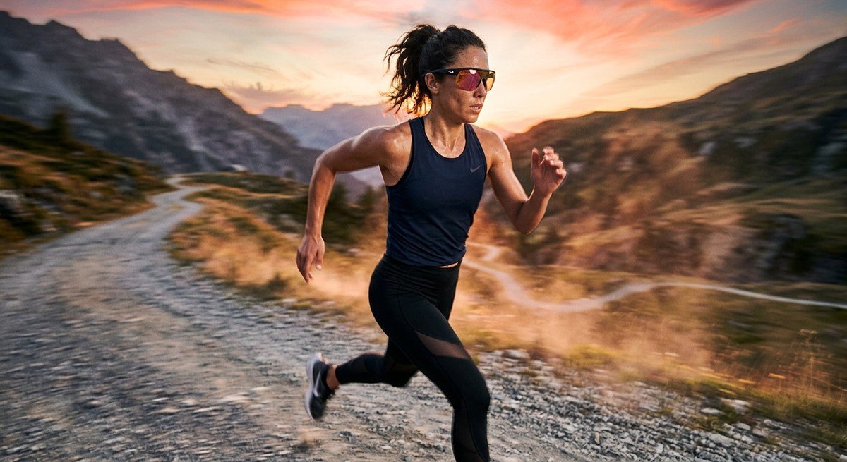 A fitness enthusiast in motion during a workout, captured with motion blur and sharp focus on the high-performance Nike Vision Prima Icon sunglasses.