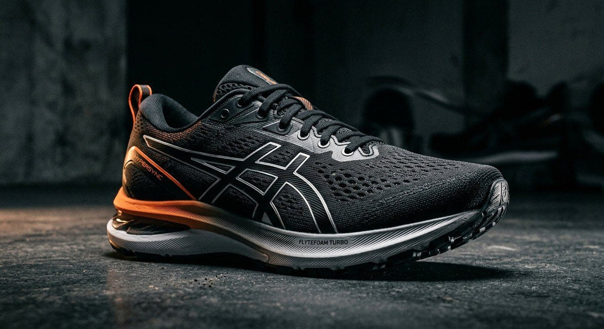 A high-contrast, moody studio shot of the ASICS Hypersync highlighting the sleek, aerodynamic design and mesh fabric detail.