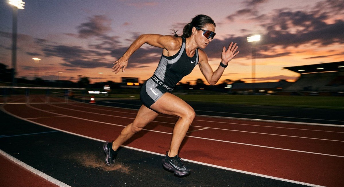 A professional athlete running on a track at dusk, wearing futuristic sports eyewear with motion blur and sharp contrast.