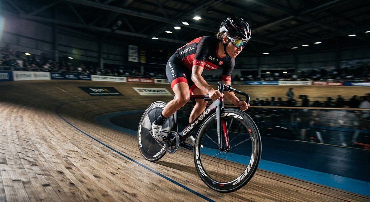 A professional cyclist in a velodrome, wearing high-performance eyewear with cinematic lighting and sharp details.