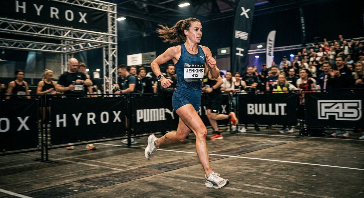 A runner captured in motion blur during an 8km Hyrox event, showcasing intense concentration and professional athletic form.