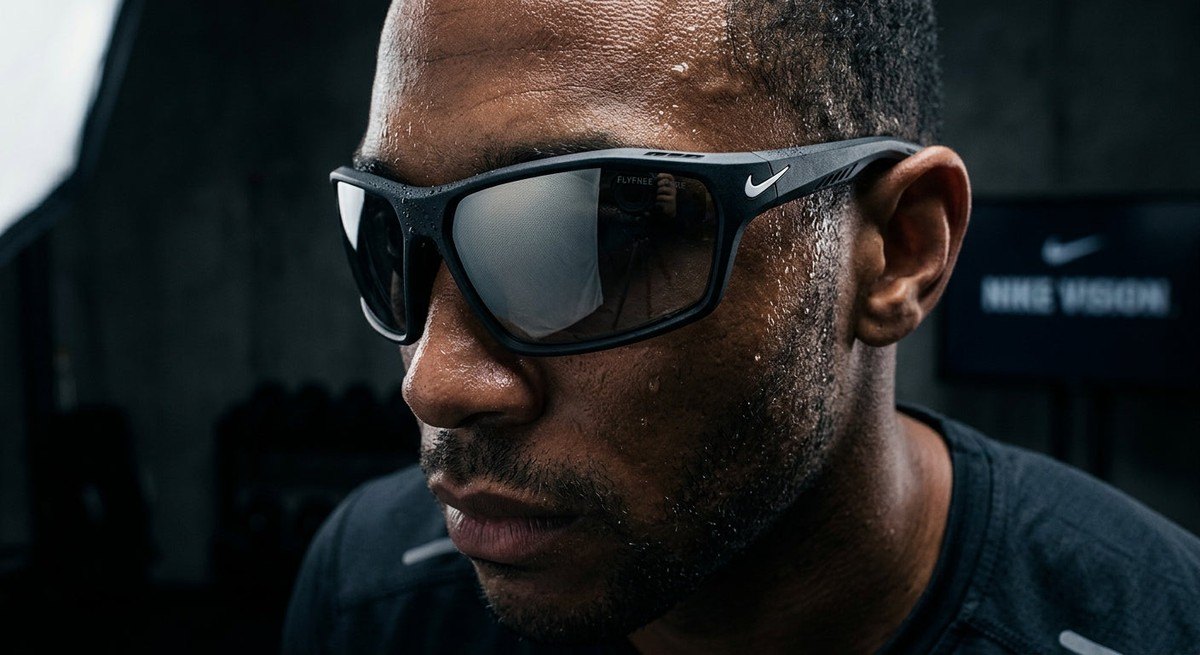 Close-up detail of the Nike Vision Flyfree lens texture and frame material, showing sharp contrast and professional studio lighting against a dark, moody background.