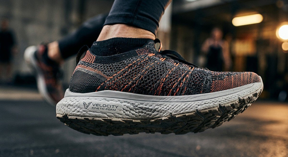 Close-up, high-detail macro photography showing the advanced knit texture and high-rebound foam midsole of a futuristic performance trainer.