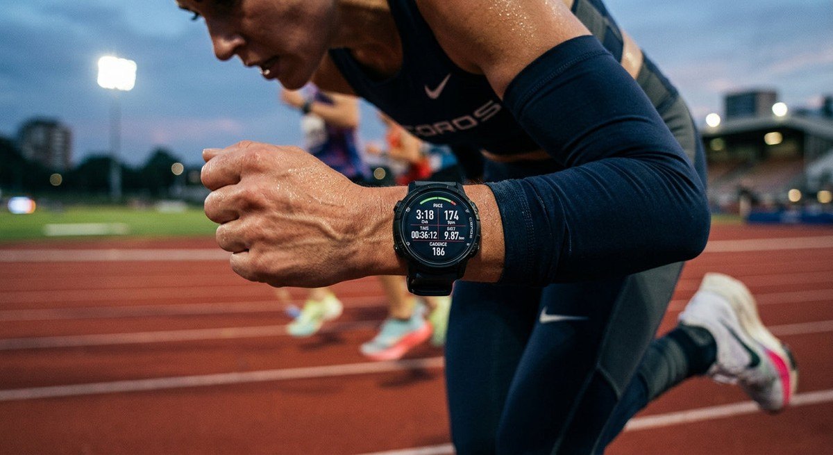 Close-up high-speed photograph of the Coros Pace 4 display showing performance metrics during an intense track session