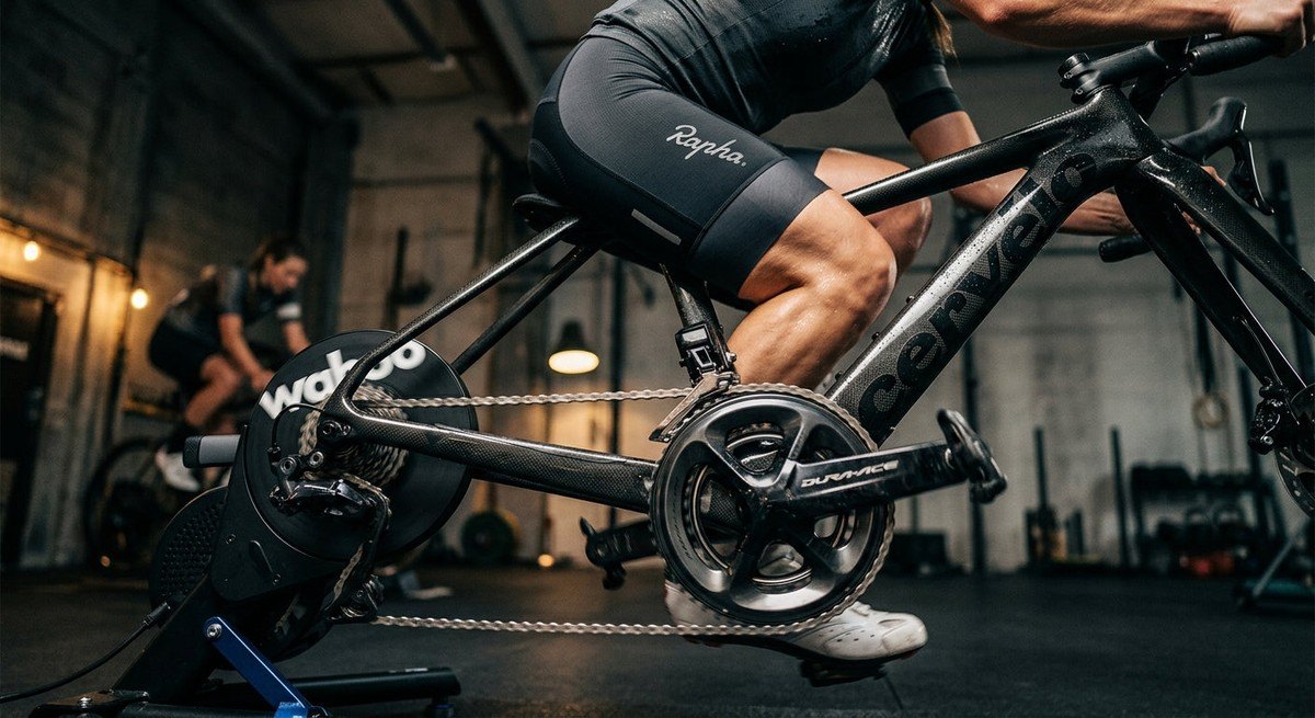 Close-up of a carbon fibre bike drivetrain in motion during a high-intensity indoor cycling session.