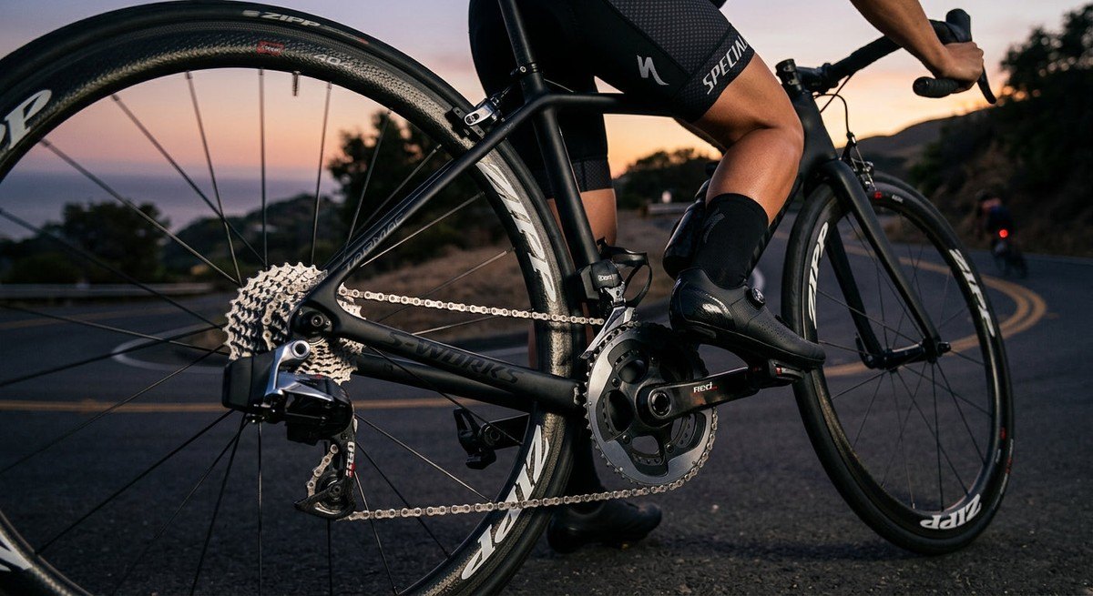Close-up of a carbon fibre road bike drivetrain with cinematic lighting highlighting the mechanical precision and clean components.