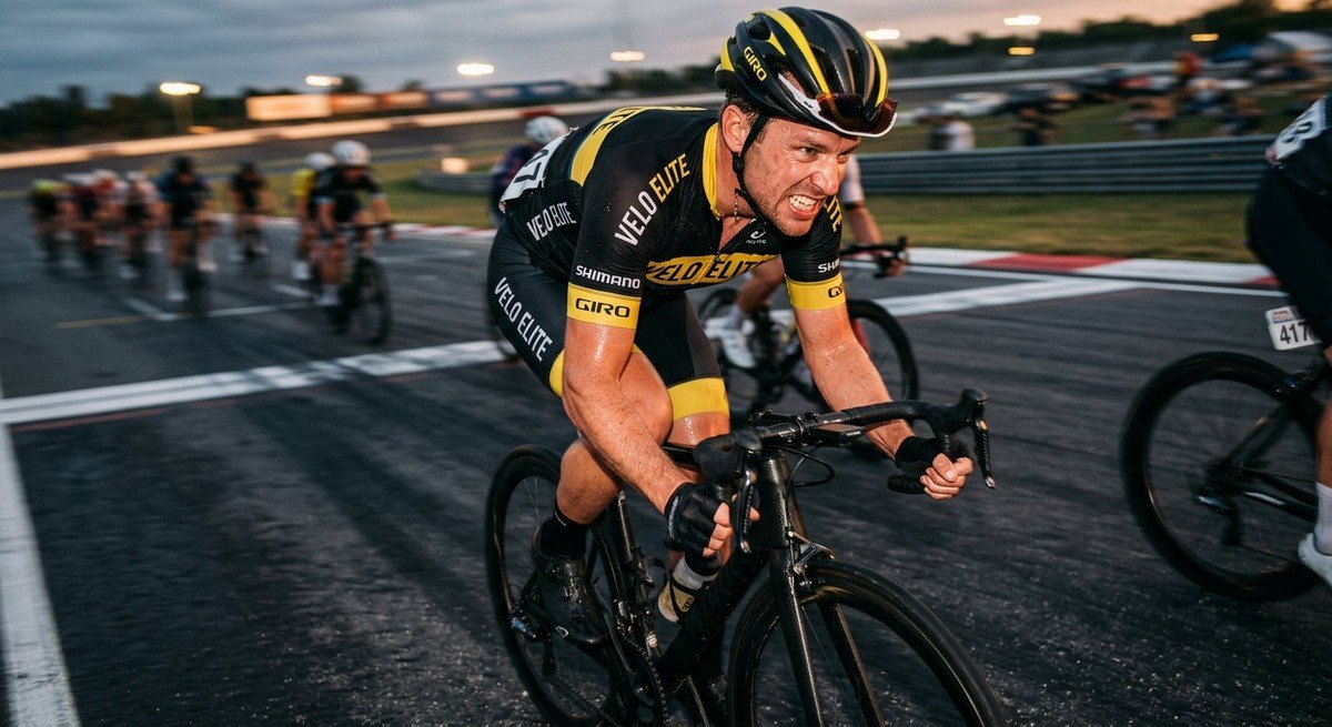 Close-up of a competitive cyclist in motion blur, focusing on the intensity and sweat during a high-power interval session.