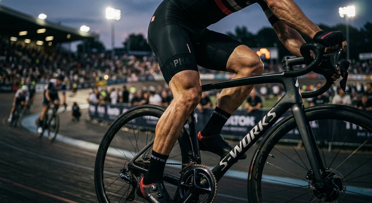Close-up of a competitive cyclist's legs in premium bib shorts, showing sharp muscle definition and realistic texture with cinematic stadium lighting.