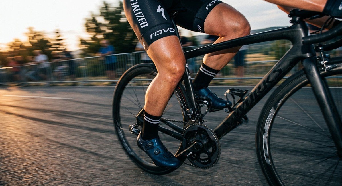Close-up of a cyclist's legs in motion with a cinematic blur effect, highlighting high-speed athletic precision and muscle detail.
