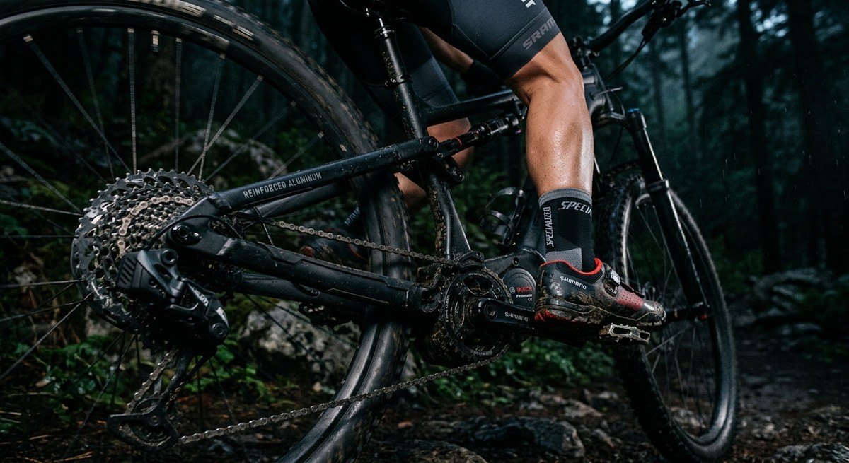 Close-up of a high-performance e-bike drivetrain showing rugged, reinforced metal components under dramatic moody lighting