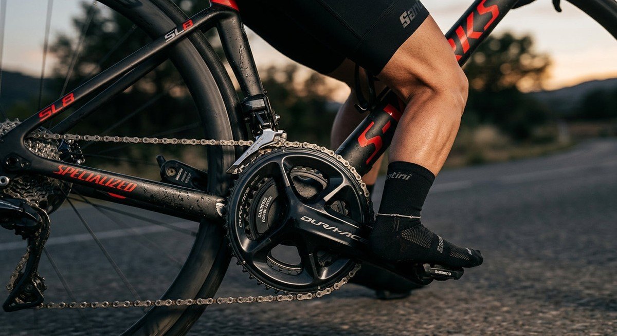 Close-up of a high-performance power meter crankset on a carbon racing bike, with cinematic lighting highlighting the metallic textures and focus.