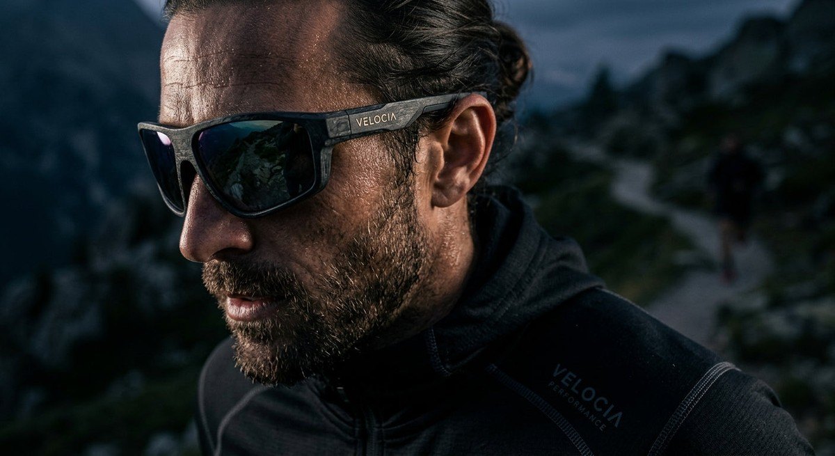 Close-up of a high-performance sunglasses frame with visible bio-composite texture and sharp, moody cinematic lighting.