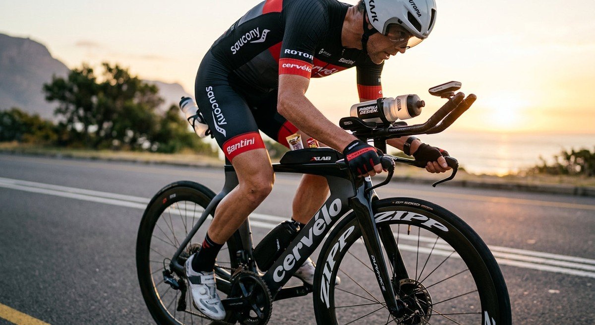 Close-up of a high-performance triathlon bike showing aero nutrition mounts and precision gear components in sharp focus.