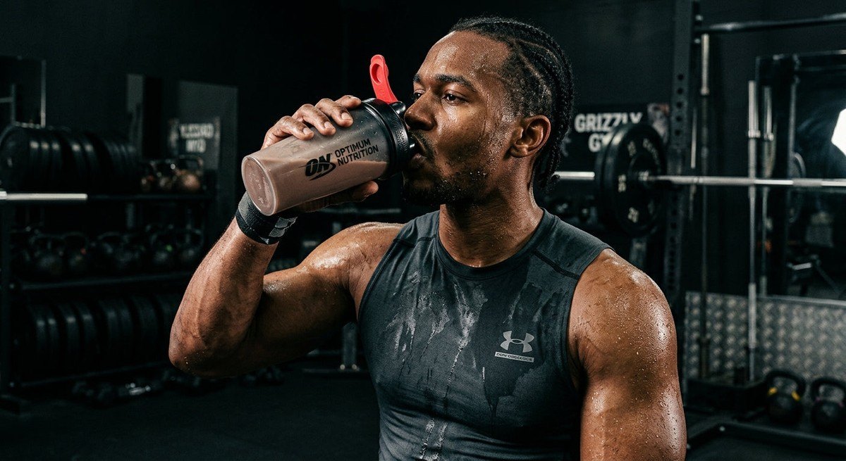 Close-up of a professional athlete drinking a protein shake after a high-intensity training session, with moody shadows and sharp textures.