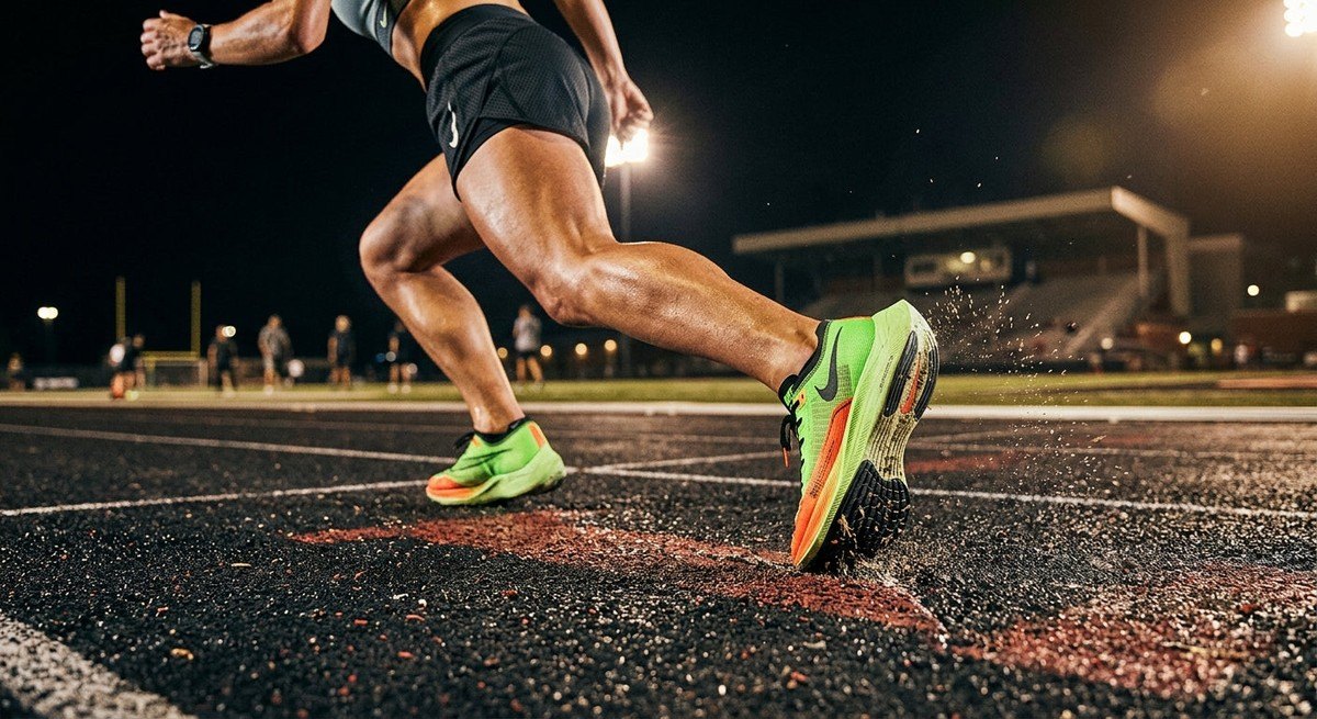 Close-up of a runner's footwear impacting a high-tech surface, showcasing sharp textures and professional athletic performance.