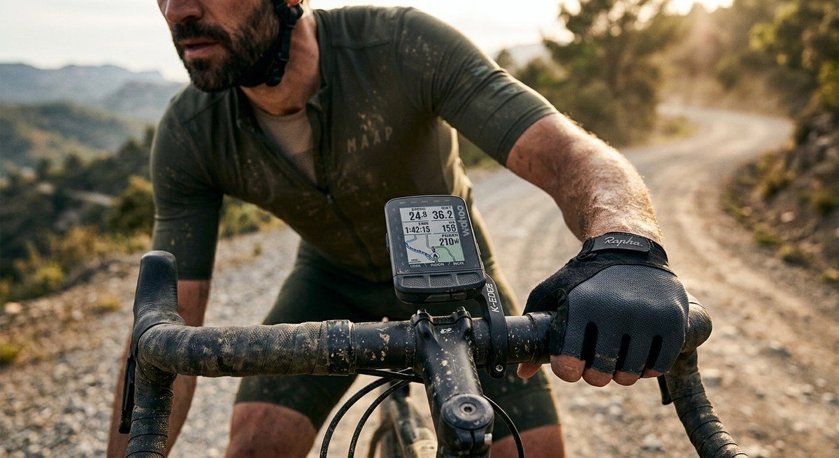 Close-up of a Wahoo Elemnt Roam V2 mounted on a gravel bike handlebar with dramatic cinematic lighting and road dust texture.