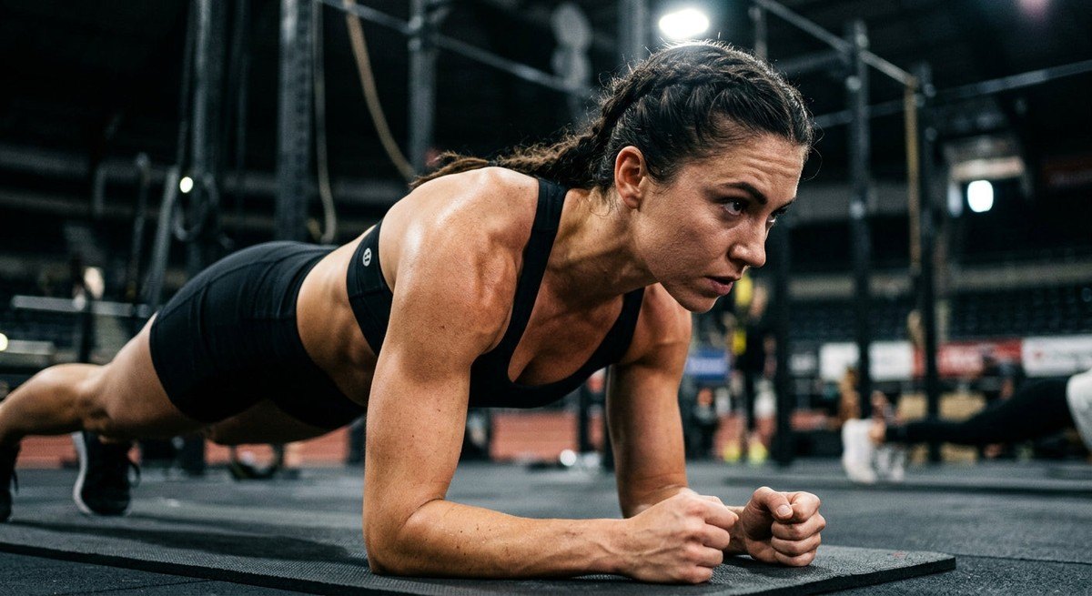 Close-up of an athlete's focused expression during a plank exercise, highlighting muscle definition and realistic skin textures under dramatic stadium-style lighting.