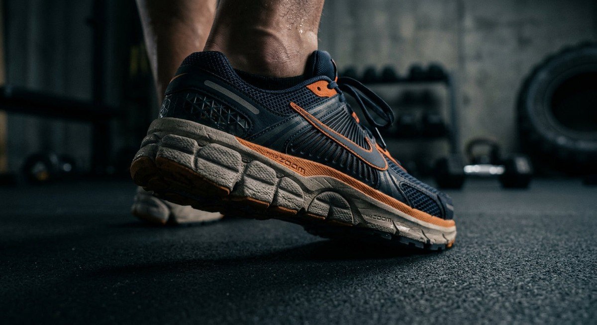 Close-up of the Nike Vomero Plus midsole texture showing high-performance foam and engineering details in a moody, low-light professional studio setting.